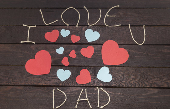 forming the word: i love DAD on wooden background