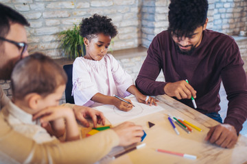 Two fathers play educational games with their children, having fun.