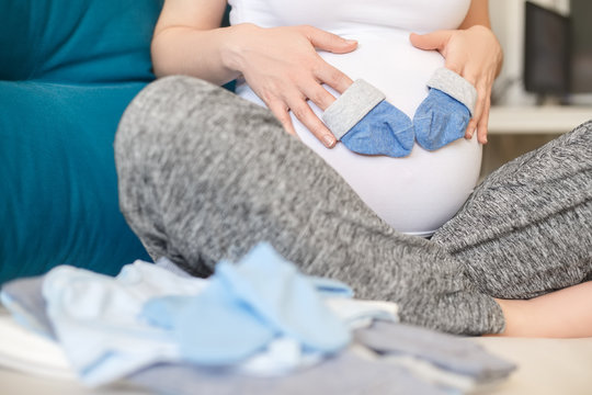 pregnant woman holding blue socks