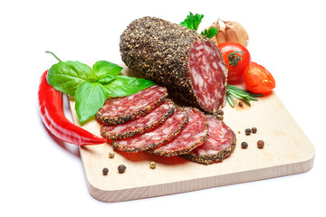 Dried organic salami sausage covered with pepper on wooden serving board