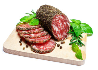 Dried organic salami sausage covered with pepper on wooden serving board