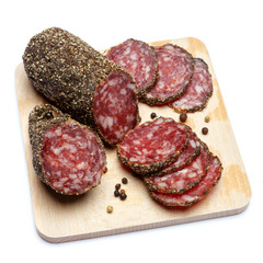 Dried organic salami sausage covered with pepper on wooden serving board