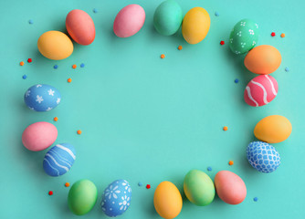 Fototapeta na wymiar Happy Easter! Turquoise background with colorful easter eggs. Top view with copy space.