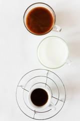 Different cups of coffee. Espresso, milk and americano with milk in cups on a white background. Place for text. Creative layout. Flat lay