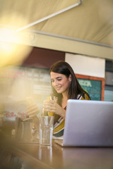 Young woman at cafe using phone. Close up.