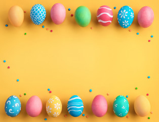 Fototapeta na wymiar Happy Easter! Yellow background with colorful easter eggs. Top view with copy space.