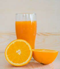 Orange and orange juice on wooden background.