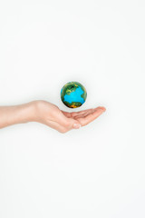 cropped image of woman holding hand near earth model isolated on white, earth day concept