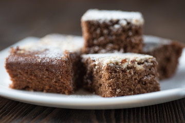 Fototapeta na wymiar Brownie stack, closeup chocolate cake in white plate on rustic wooden table