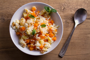 Healthy food: rice porridge with pumpkin, apples and raisins. Vegetarian or diet dish of rice and pumpkin good for breakfast. View from above, top