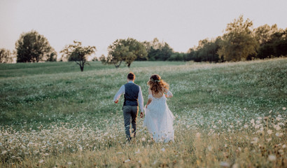 Beautiful bride and groom at sunset in green nature.