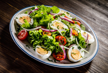 Boiled eggs and vegetables on wooden table