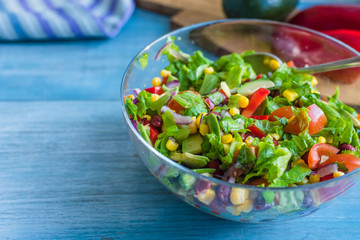 Traditional vegetarian American Southwest Salad on a glass bowl and rustic background - copy space for a recipe