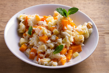 Healthy food: rice porridge with pumpkin, apples and raisins. Vegetarian or diet dish of rice and pumpkin good for breakfast