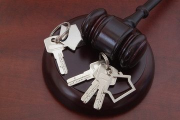 Divorce concept with gavel and keys with key holders on wooden table
