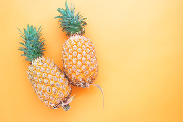 Flat lay whole pineapples on orange color background