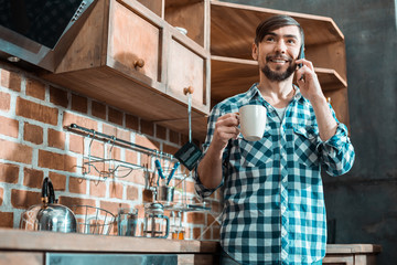 Positive man standing in the kitchen