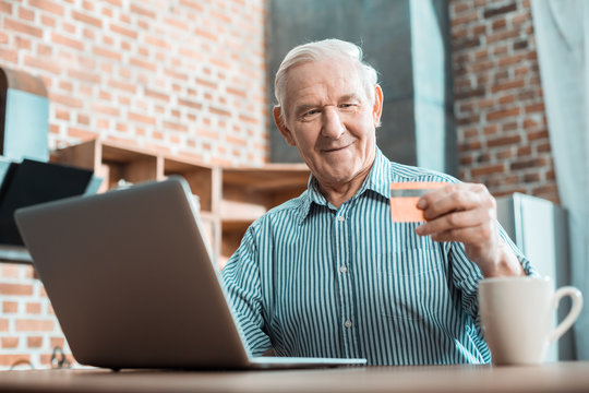 Positive Aged Man Looking At The Credit Card