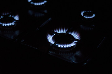 четыре горелки горят на газовой плите в темноте © dzmitry_2014