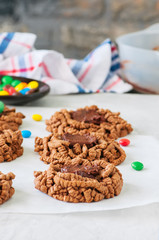 Chocolate bird's nest cookies decorated with colorful candies on a white background.