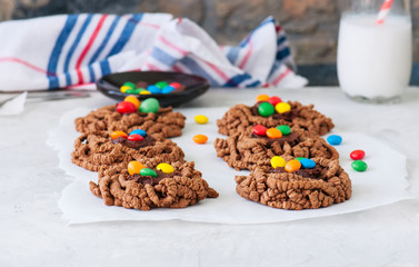 Chocolate bird's nest cookies decorated with colorful candies on a white background.