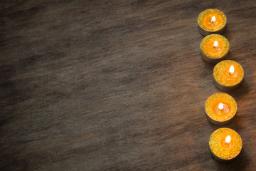 Burning candles on the dark wooden table
