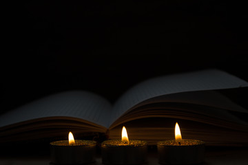 clear book opened near burning candle