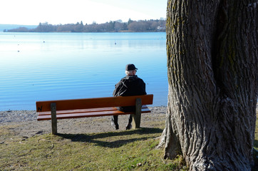 Man on a bench by the lake