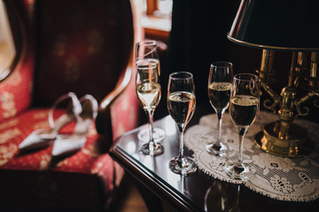 in the room on table there are glasses with champagne, on the glass a 