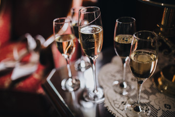 in the room on table there are glasses with champagne, on the glass a 