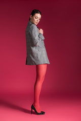 Woman with thin legs in red nylon tights on red background