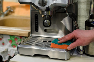 Barista cleaning coffee machine at cafe