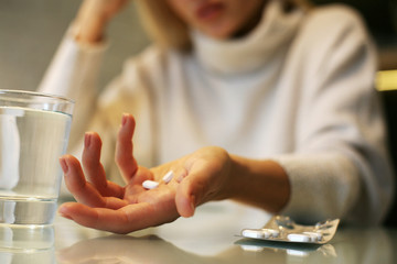 Pills in woman hands.