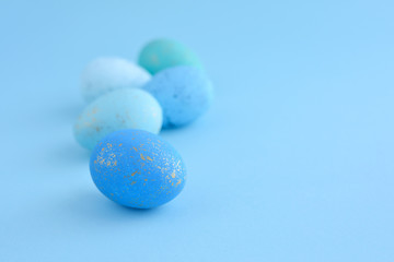 Easter eggs on blue background with empty space