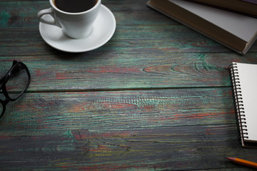 A cup of coffee in the workplace on a wooden table. A cup of coffee in the workplace on a wooden table. The concept of working outside the office