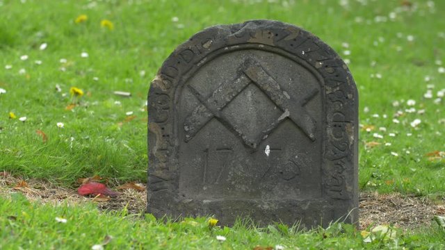 Small old gravestone in green grass