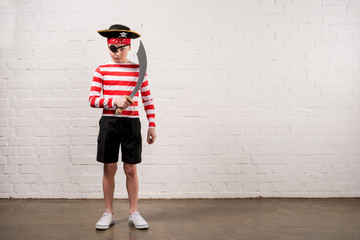 little boy pretending to be a pirate with toy knife - Powered by Adobe