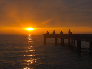 loseup view peaceful beach with unidentified people during sunset. Selective focus and crop fragment.