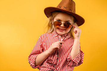 stylish cowgirl in hat and sunglasses, isolated on yellow