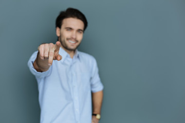 It is you. Selective focus of a male finger being pointed at you by a nice positive joyful man