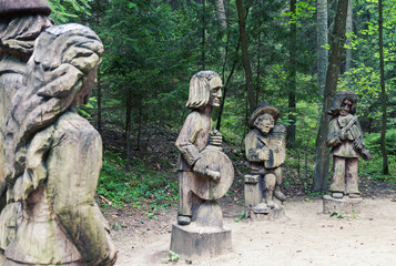 Traditional Lithuanian wood carving art sculptures of folk musicians in public nature park in...