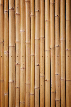 Close-up of a natural bamboo wall background with warm tones and vignette