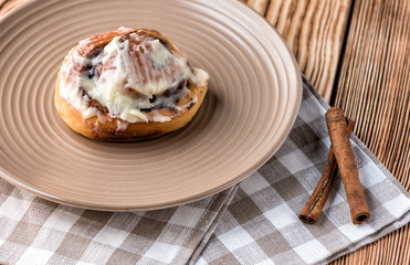 Bun roll with cnnamon on a wooden table