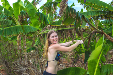 Young Girl in bikini takes banana
