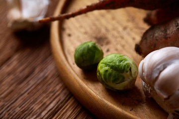 Colorful various of organic farm vegetables with fresh carrots on wooden rustic background, top view, selective focus