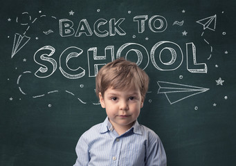 Adorable little boy with blackboard and back to school concept