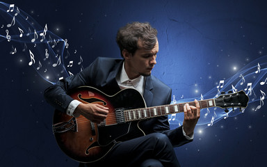 Obraz premium Lonely musical composer with guitar and sparkling musical notes around