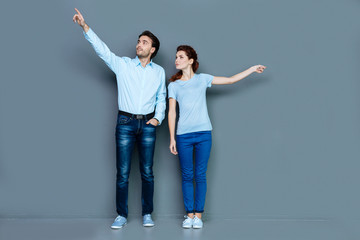 Young people. Nice joyful young people standing near her friend and smiling while looking at something interesting