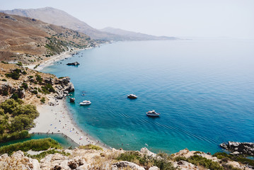 Obraz premium Panorama of Preveli palm beach at Libyan sea, turquoise bay with ships and mountains , Crete , Greece