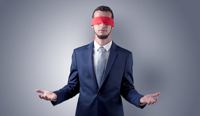 Covered eye, indecisive businessman standing blind in front of a wall